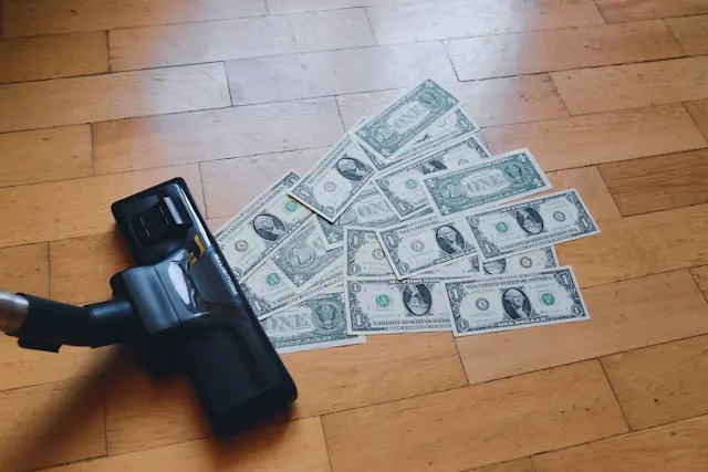 aspiradora con muchos billetes en el suelo