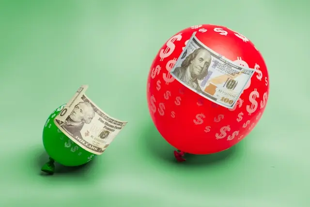 un globo  pequeño verde con dolares y un globo rojo grande